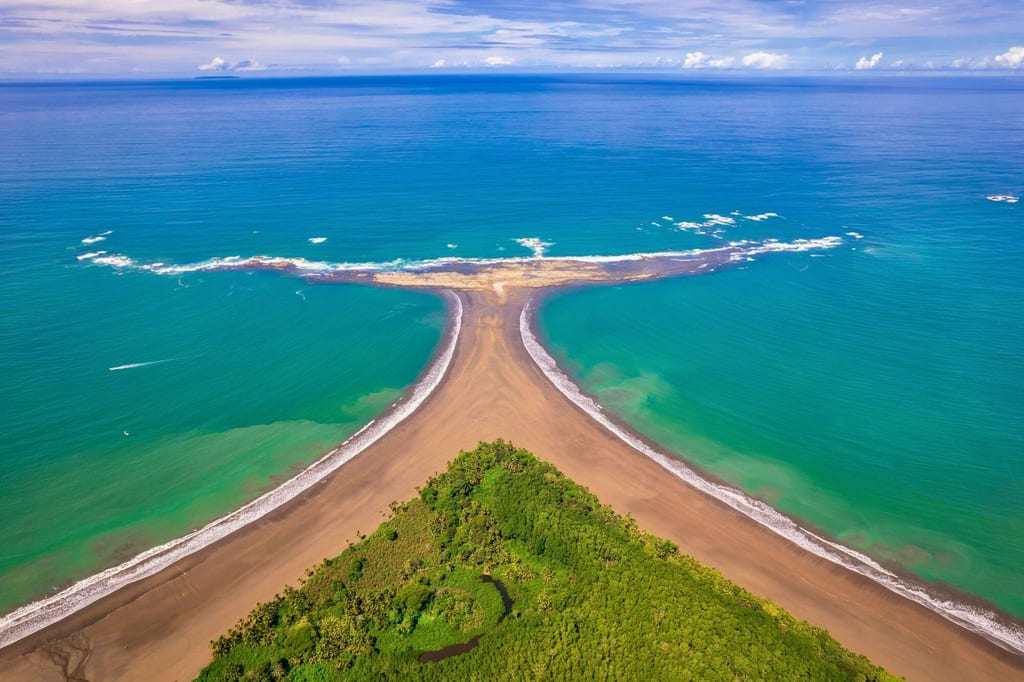 Luftaufnahme der walflossenförmigen Sandbank an der Küste von Uvita, Costa Rica, mit türkisblauem Meer.