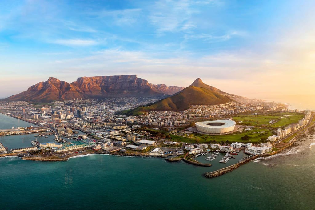 Luftbild von Kapstadt mit Tafelberg, Lion’s Head, Stadion und Küste in warmem Abendlicht.