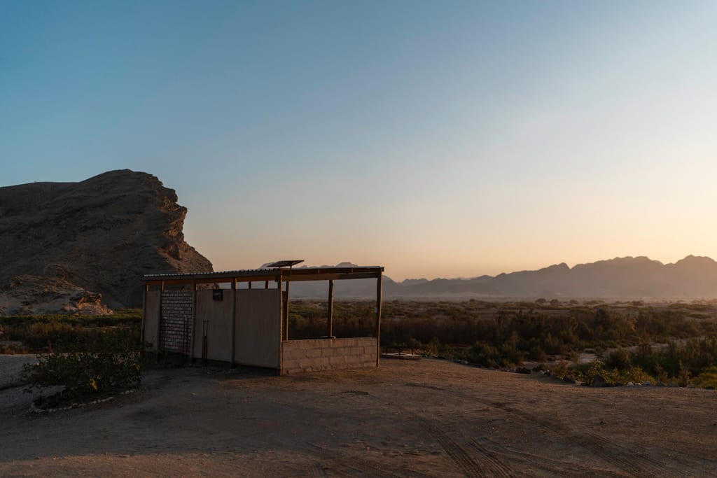 Offene Hütte vor weitem Wüstenpanorama im warmen Abendlicht.