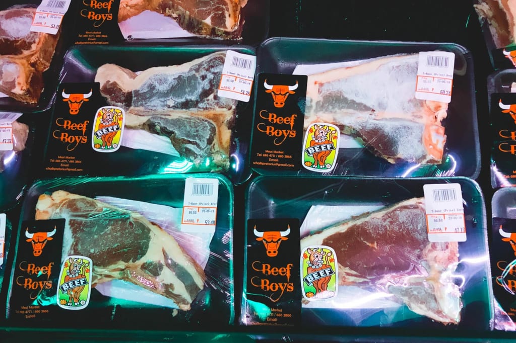 Vakuumverpackte Rindersteaks in schwarzen Schalen mit Preisschildern und Aufklebern