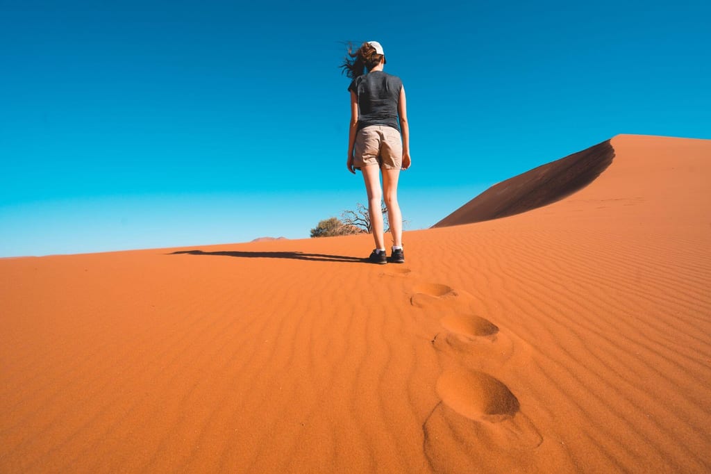 Mit Wanderschuhen auf einer Düne in Namibia