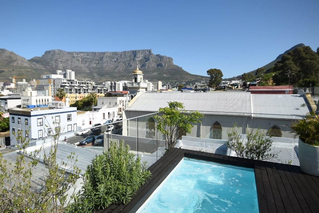 Dachterrasse mit Pool und Blick auf Stadt und markanten Tafelberg bei klarem Himmel