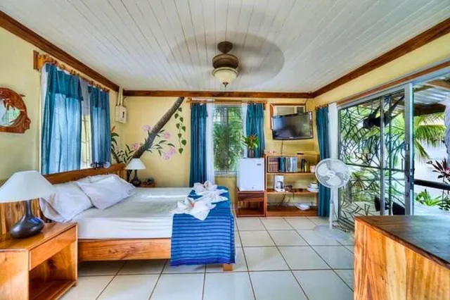 Helles Schlafzimmer mit Doppelbett, Holzmöbeln und Schiebetür zum begrünten Balkon