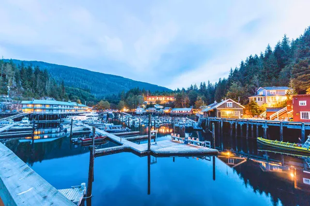 Hafen von Telegraph Cove mit Booten, Stegen und beleuchteten Häusern bei blauem Abendhimmel