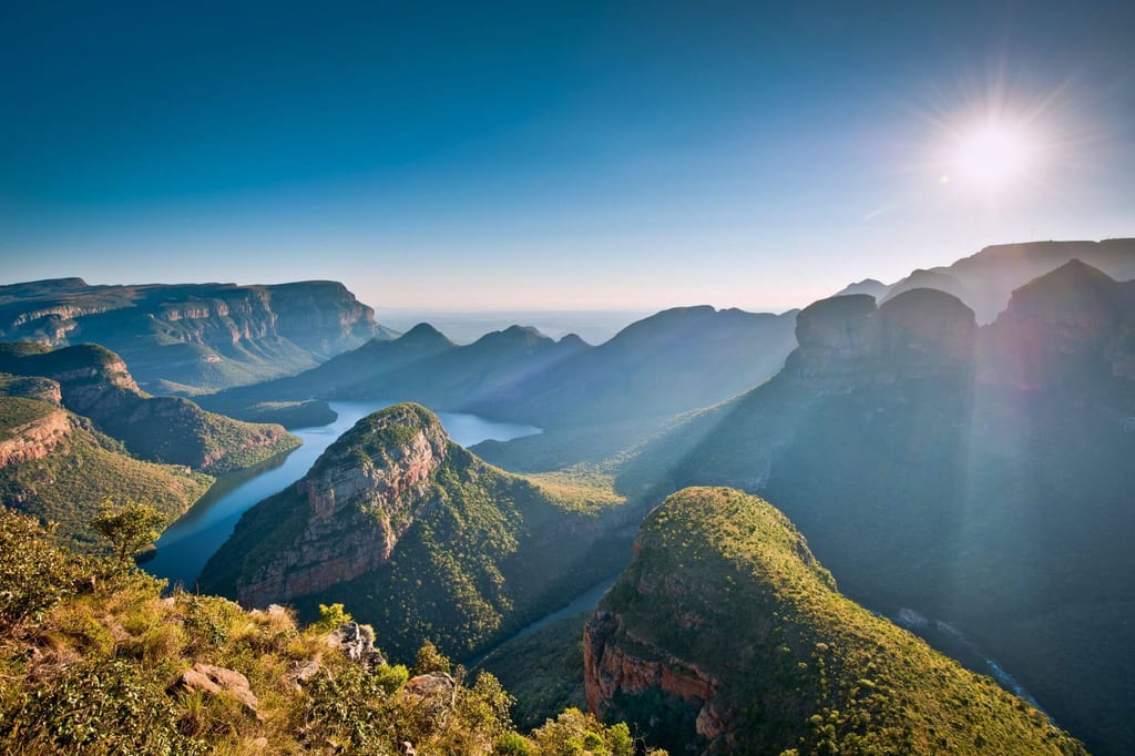 Panoramablick auf Canyon mit Fluss und steilen grünen Felsklippen unter klarem Himmel