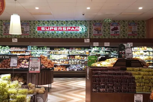 Blick in die Obst- und Gemüseabteilung eines Supermarkts mit SuperSpar-Logo und Preisschildern.