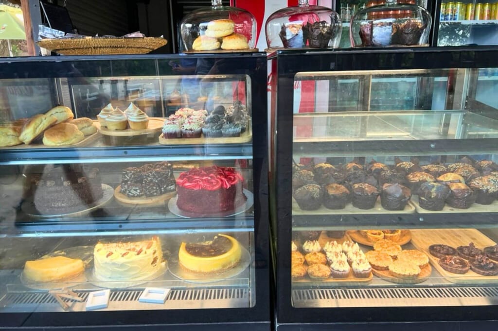 Gekühlte Vitrinen mit Kuchen, Torten, Muffins und anderem Gebäck in einer Bäckereiauslage.