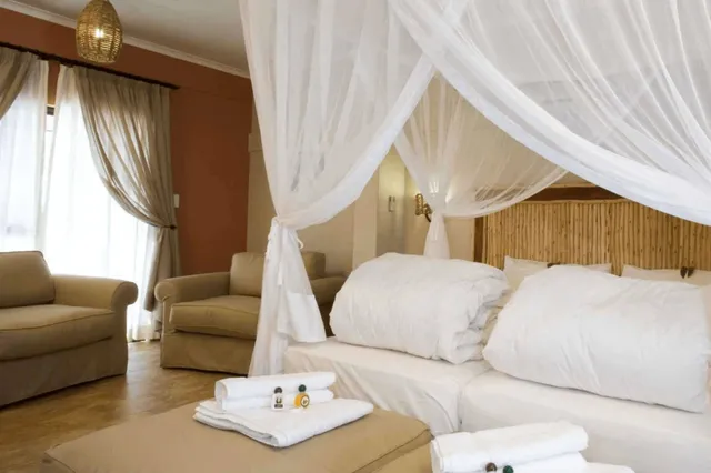 Gemütliches Hotelzimmer mit weißem Moskitonetz über dem Bett und gefalteten Handtüchern