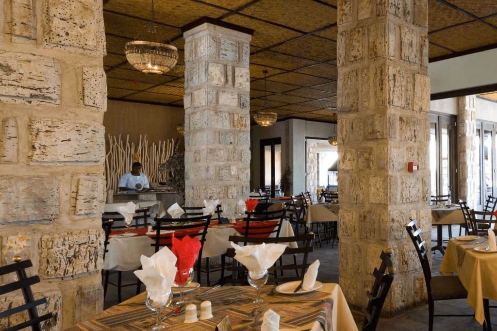 Ruhiges Restaurant mit Steinsäulen, gedeckten Tischen und warmem Licht