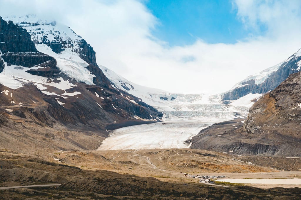 Weites Gletschertal mit Eisfeld, Felswänden und moränenreicher Vorderansicht bei Tageslicht.