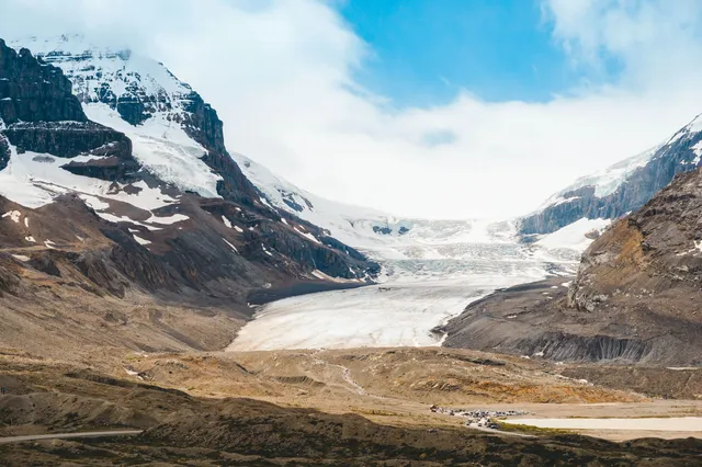 Weites Gletschertal mit Eisfeld, Felswänden und moränenreicher Vorderansicht bei Tageslicht.