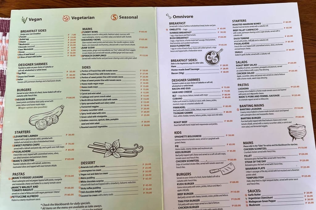 Offenes, zweiseitiges Restaurantmenü mit vielen Gerichten und Symbolen für Vegan/Vegetarian/Seasonal