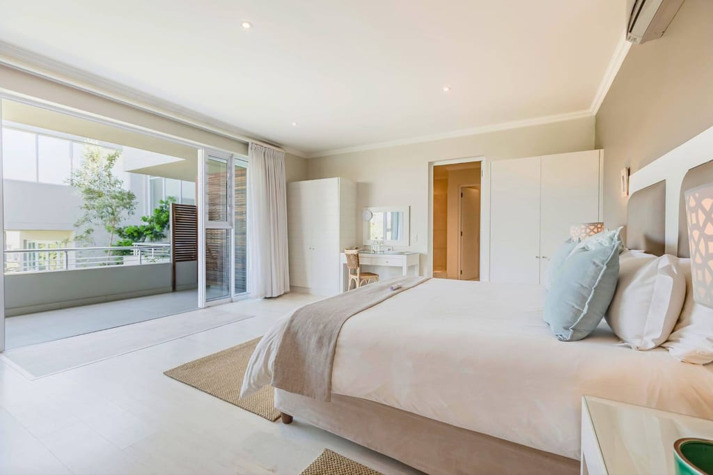 Helles modernes Schlafzimmer mit offenem Balkon und Doppelbett, ruhige Tageslichtstimmung